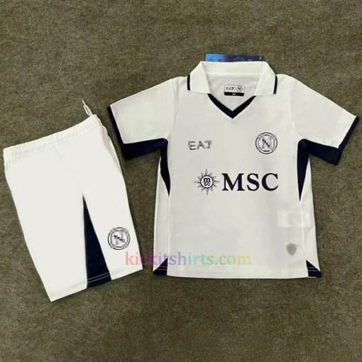 Napoli Away Kit Kids 202425 in white with black accents, featuring a 3D SSC Napoli badge, all-over "N" pattern, and special fingerprint hologram crest at the bottom.