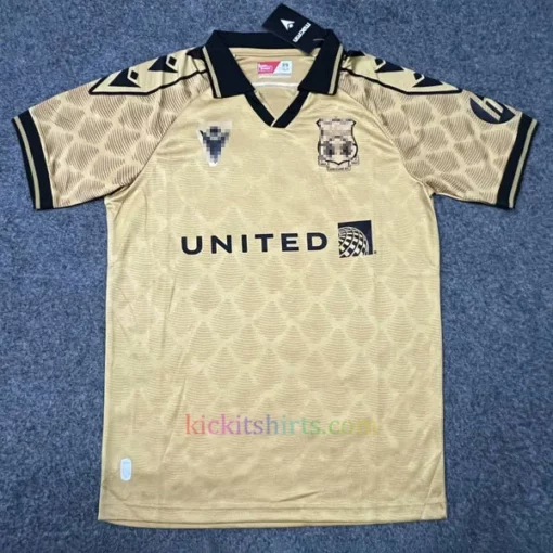Wrexham AFC 2024/25 third kit in gold, featuring a polo collar, black badge, dragon-scale sleeves, and a tribute detail on the back.