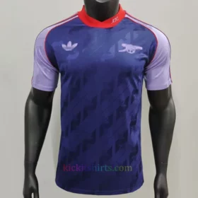 Arsenal Originals Shirt 2024/25 Stadium Edition front view in elegant navy blue with subtle patterns, featuring a heat-applied cannon emblem on the chest and a ribbed crewneck.
